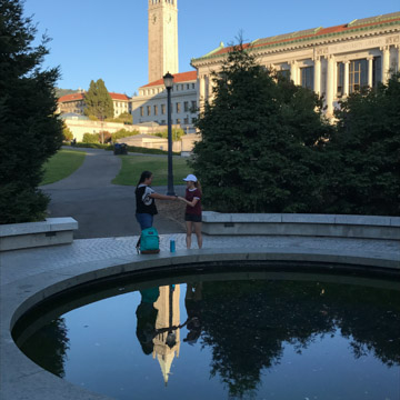 Campus view with Memorial Pool in foreground, Sather Tower in background, and Doe Memorial Library at right (photo taken in 2017)
