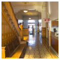 Interior view of entry hall showing stairway, woodwork, and tile flooring, looking north