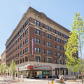 The retail front of the former Cumberland Arms Hotel (1917) at 10 N. Liberty Street, now an apartment building, has a mid-twentieth-century storefront modernization with glass curved at its corners and black Vitrolite.